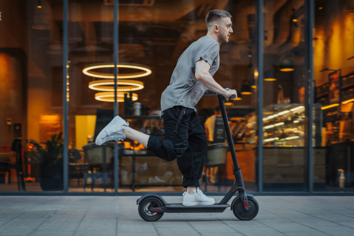tips-to-safely-ride-and-enjoy-an-electric-scooter a man riding a skateboard up the side of a road